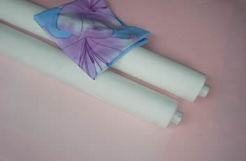 A high-end scarf in placed on two rolls of polyester textile printing mesh