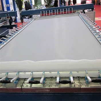 A piece of white glass printing mesh is mounted to metallic frame before printing.