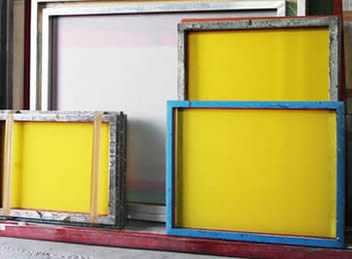 Several different sizes of nylon printing screen leaning on the wall.